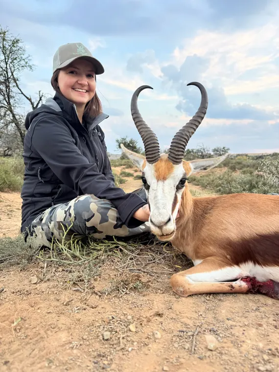 Hunter with a springbok trophy in open South African country