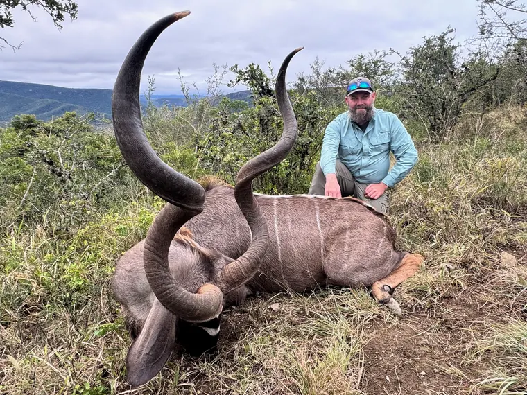 Hunter with a mature spiral horned trophy in Eastern Cape brush country