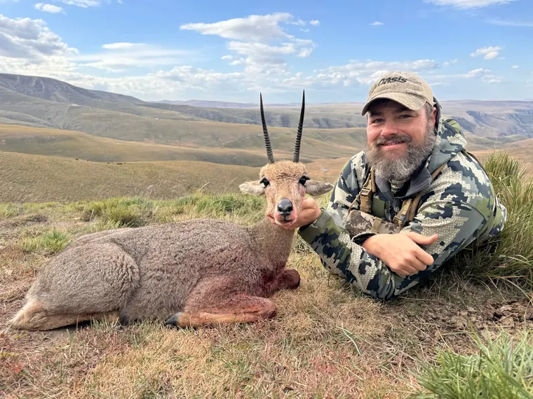 Hunter with a small antelope trophy overlooking Eastern Cape hills