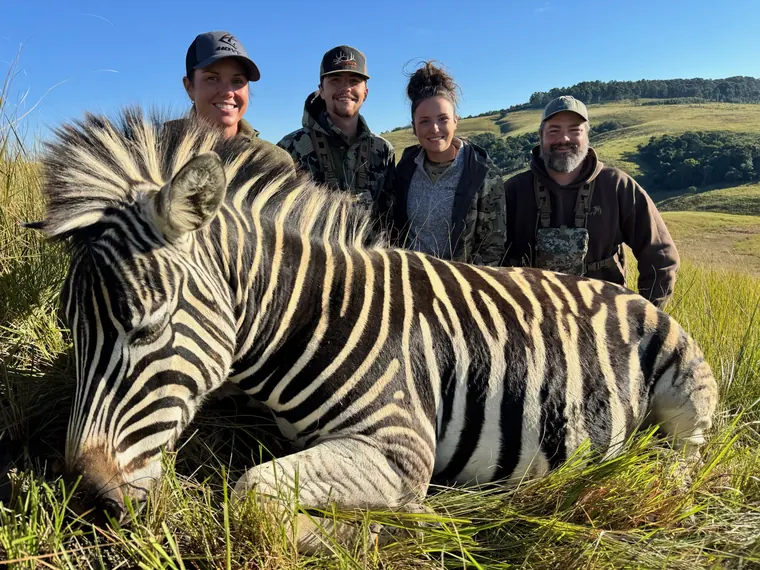 Hunting party with a zebra trophy in rolling Eastern Cape country