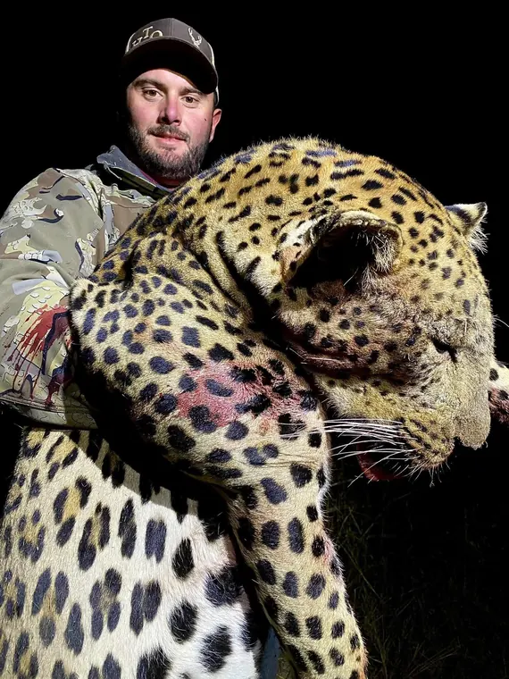 Hunter with a leopard at night
