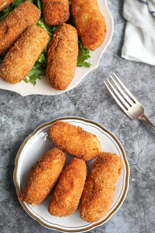 Golden croquettes served in bowls on a stone table