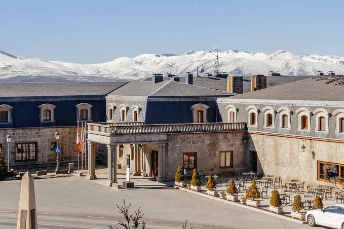 Parador de Gredos exterior with snowy mountains behind it, Spain