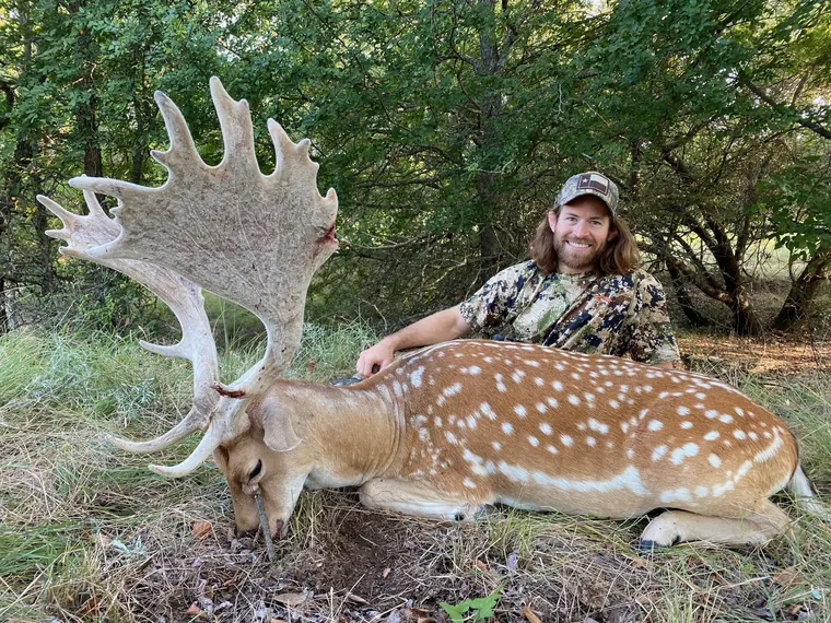 Hunter with a fallow buck in wooded Dublin ranch country