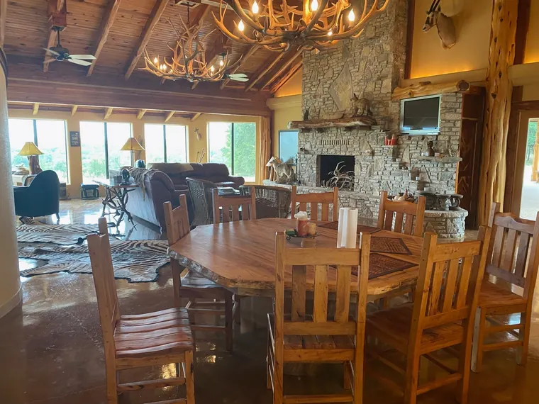 Wooden dining table, stone fireplace, and mounted trophies inside the Dublin lodge