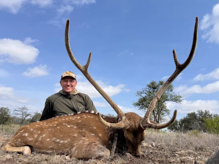 Hunter with an axis buck in Texas